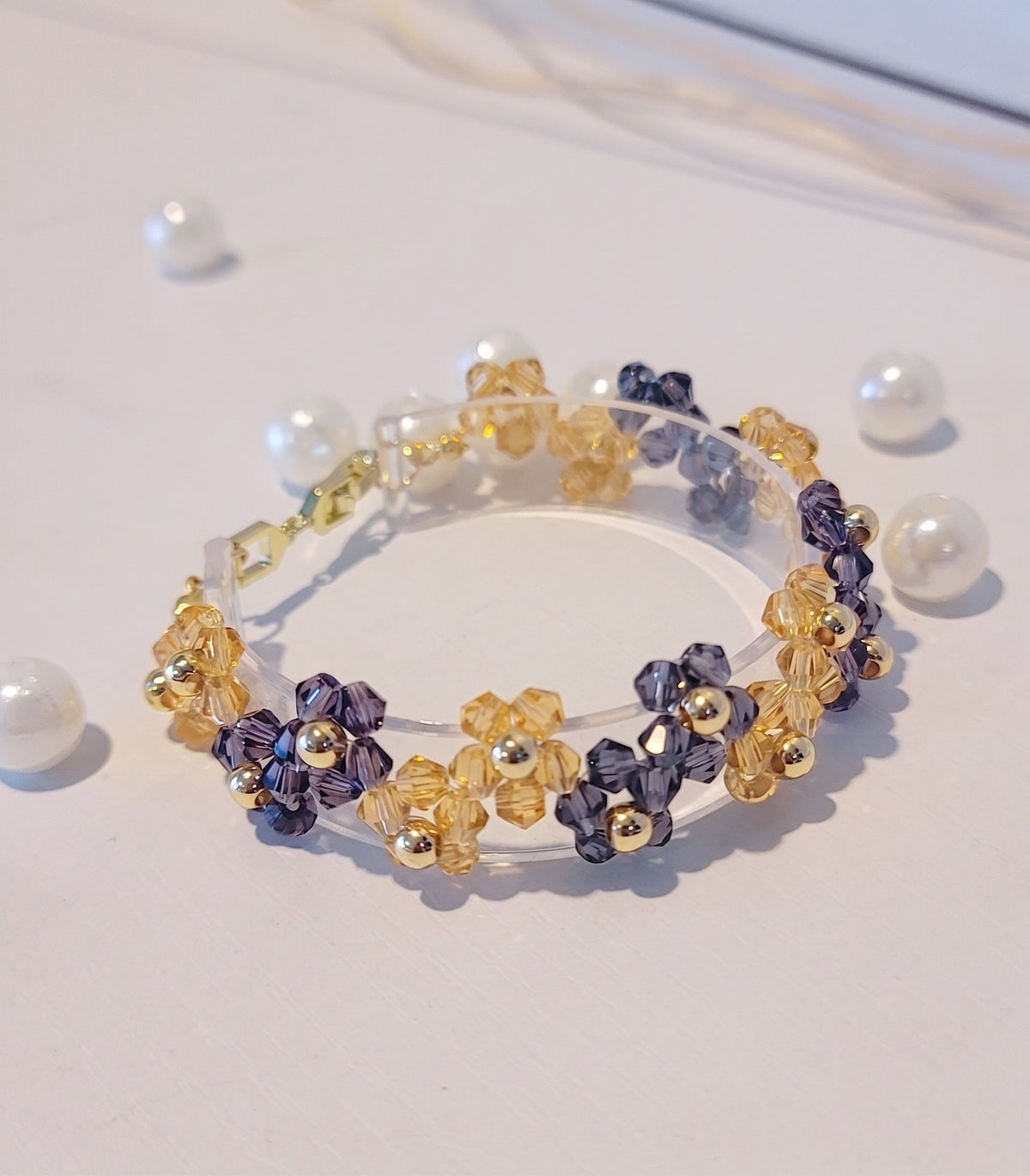 pulsera con un patron de flores hechas con cuentas de cristanb