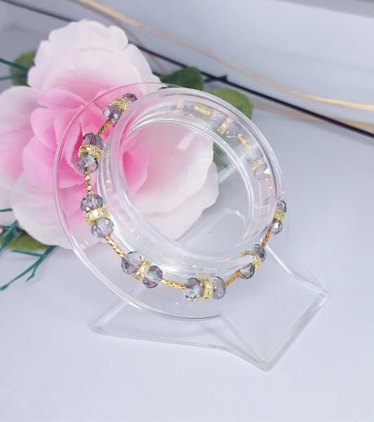 hermosa pulsera color gris y detalles dorados